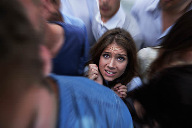 Shot of a fearful young woman feeling trapped by the crowd